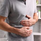 Muškarac drži ruke u predjelu bolnog abdomena.